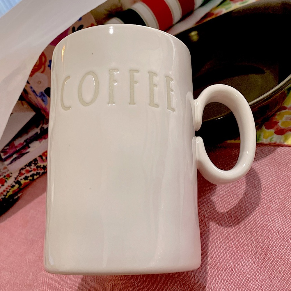 Tall Coffee Mug by Rae Dunn. White w/beige Writing and design. Dark Teal inside.